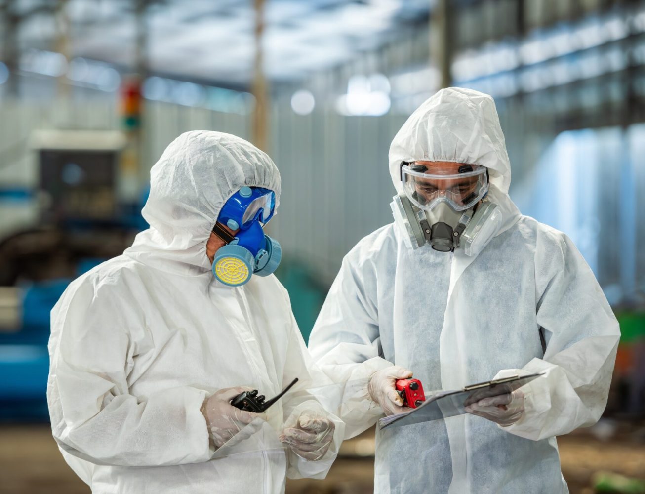 Electricians in a hazardous area wearing a full kit and masks